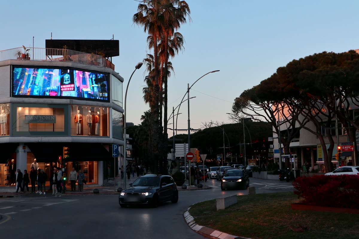 La pantalla iluminada al anochecer sobre el eje comercial