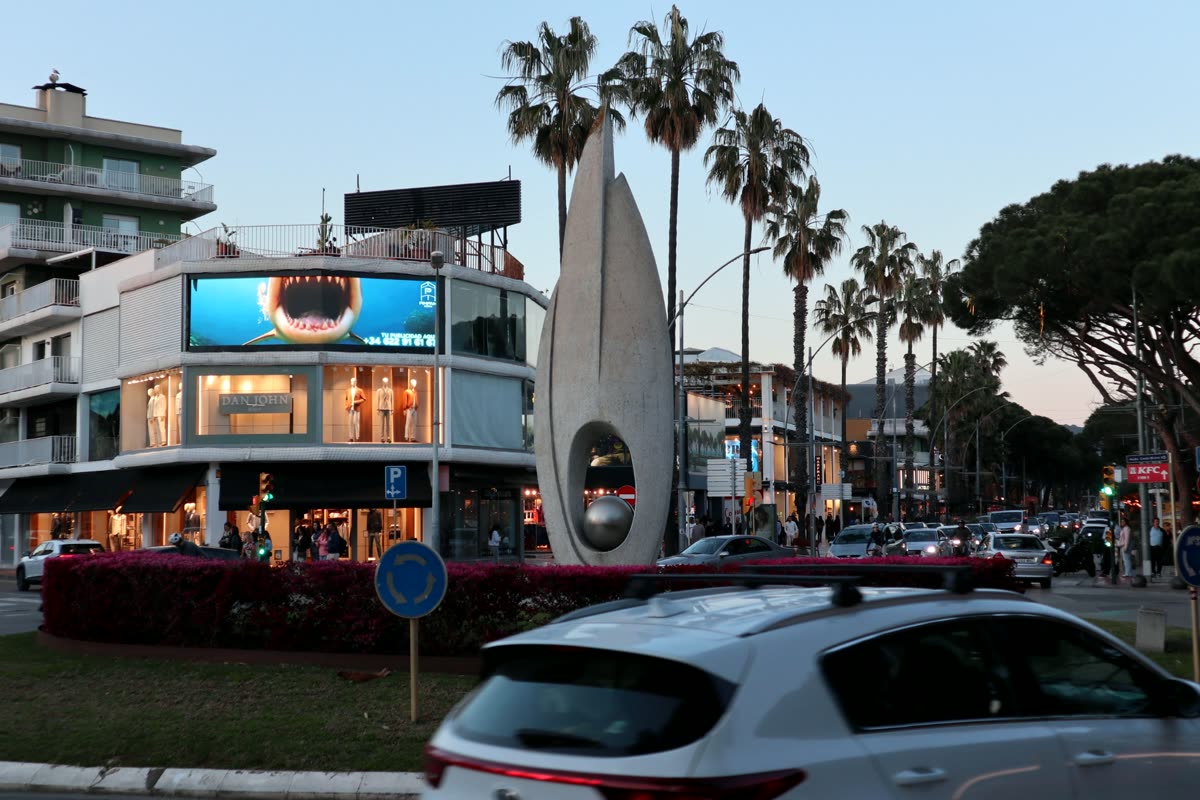 La Perla sobre la rotonda principal de Platja d'Aro, con la escultura en primer plano
